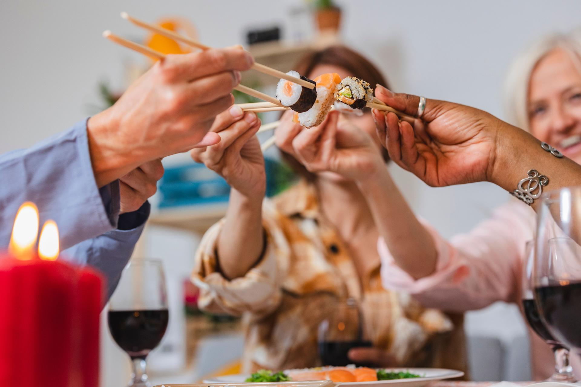 group women eating sushi, at home